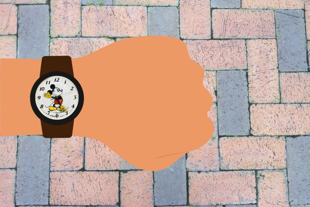 A graphic of a Mickey Mouse watch on a wrist with a perspective of looking towards the ground.