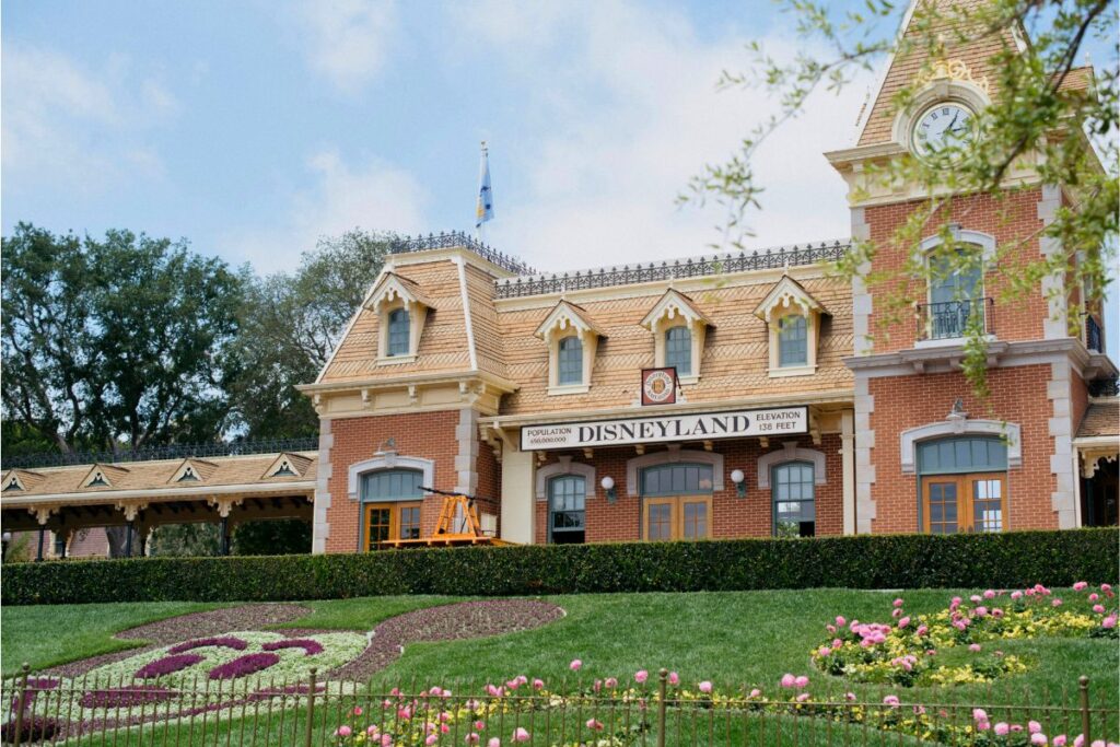 A photo of the Disneyland Railroad station and a floral image of Mickey Mouse at the front of Disneyland.