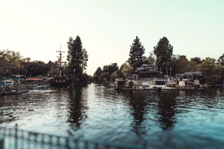 A tranquil scene featuring a boat anchored in the calm center of a beautiful lake, surrounded by nature.