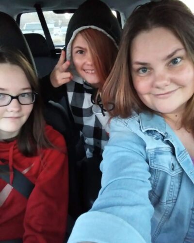 Girls and Me A mother and her two daughters enjoy a ride together in a car.